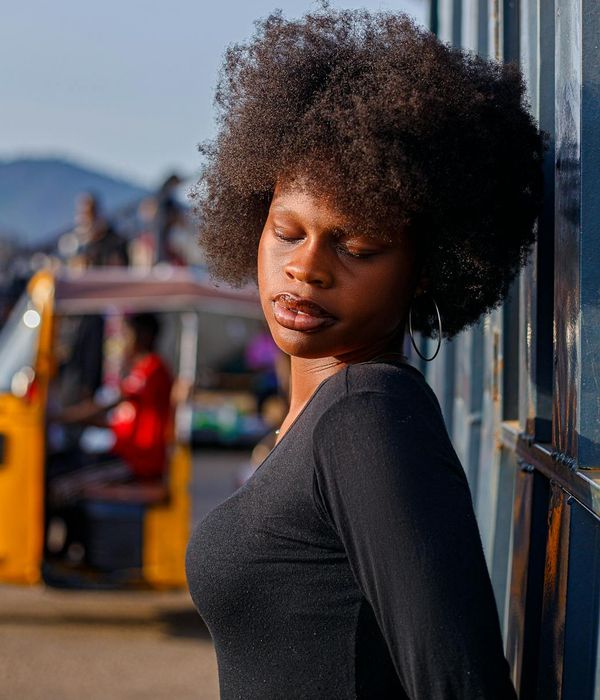 Woman in a calm, focused pose against a deep orchid background.